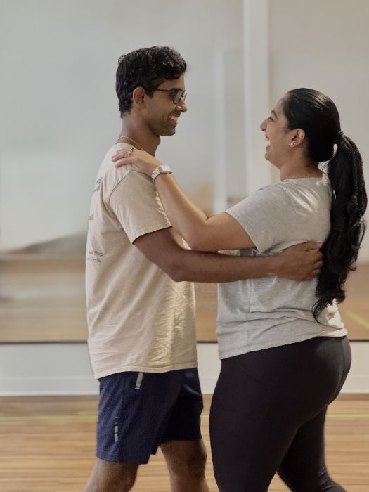 A couple laughing together in a dance hold