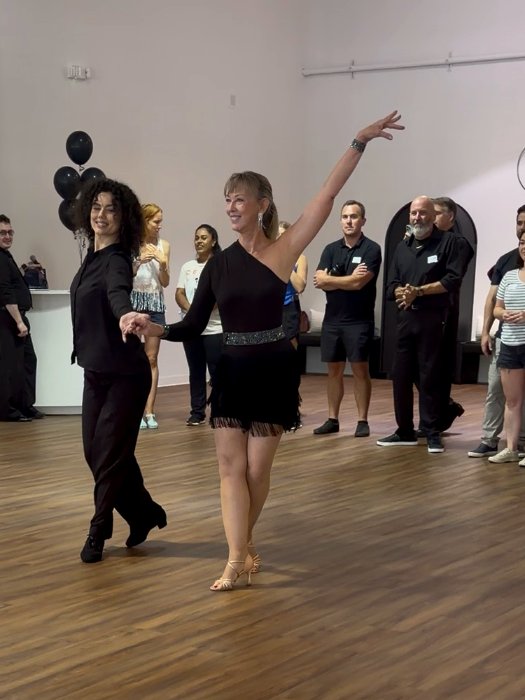 Two dancers finishing a routine with an arm raised
