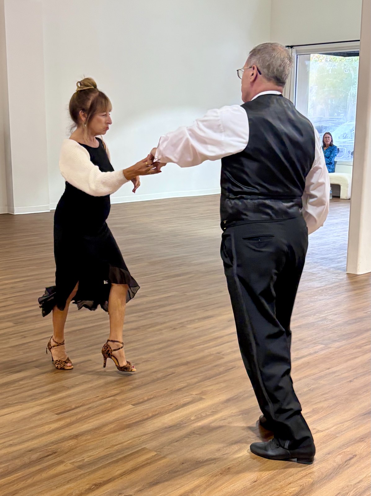 A couple performing a Latin dance on the studio floor