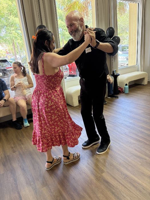 A couple dancing by the studio windows
